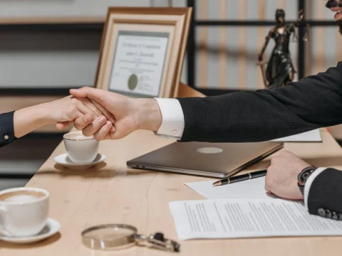 Business handshake over a desk with paperwork